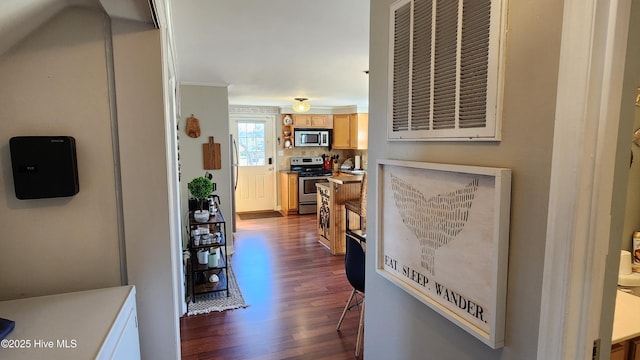 hallway featuring visible vents, ornamental molding, and dark wood finished floors