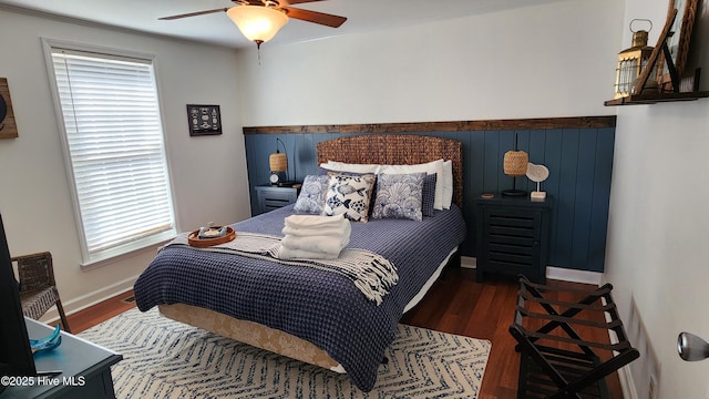 bedroom featuring dark wood-style floors, baseboards, and a ceiling fan