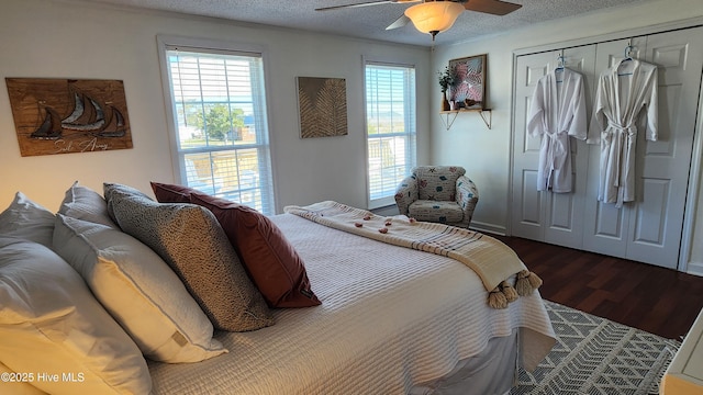 bedroom featuring a closet, a ceiling fan, dark wood finished floors, and a textured ceiling