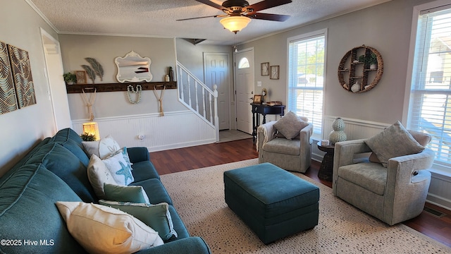 living room featuring a wainscoted wall, stairway, a wealth of natural light, and a textured ceiling