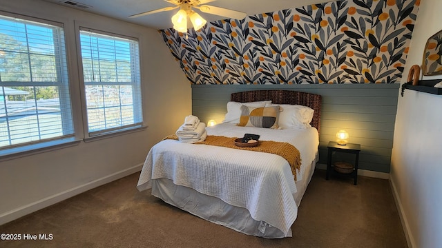 bedroom with ceiling fan, dark colored carpet, visible vents, and baseboards