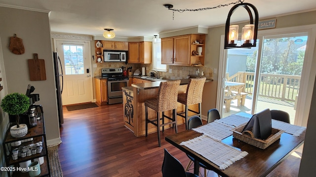 kitchen featuring appliances with stainless steel finishes, brown cabinets, ornamental molding, a kitchen bar, and open shelves