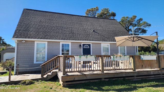 rear view of house with a deck and roof with shingles