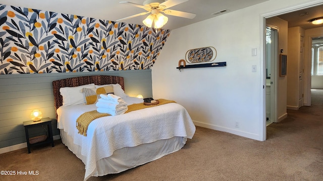 carpeted bedroom with a ceiling fan, visible vents, and baseboards