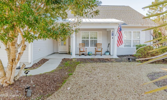 view of front of home featuring covered porch, roof with shingles, and an attached garage