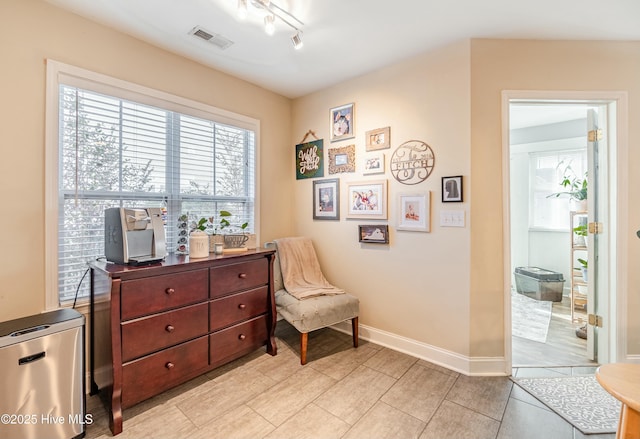 sitting room with track lighting, visible vents, and baseboards