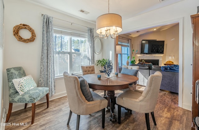 dining area with plenty of natural light, visible vents, and dark wood finished floors