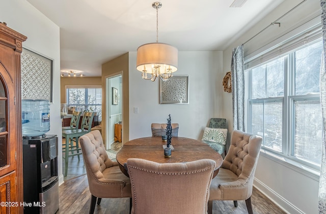 dining room with dark wood-style floors, a notable chandelier, and baseboards