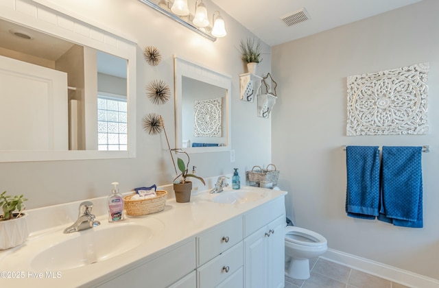 bathroom with toilet, visible vents, a sink, and tile patterned floors