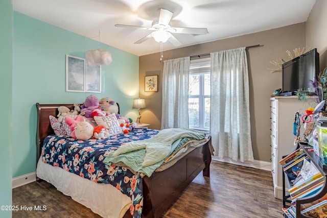 bedroom with a ceiling fan, baseboards, and dark wood-type flooring