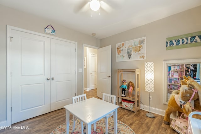 interior space featuring wood finished floors, a ceiling fan, and baseboards