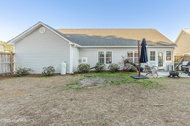 back of property featuring roof with shingles, a patio, and fence