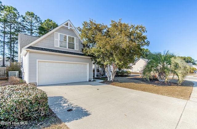 view of front of house featuring central AC unit, concrete driveway, a shingled roof, and an attached garage