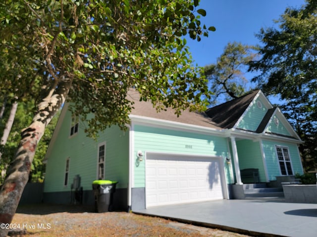 view of side of property featuring driveway and an attached garage