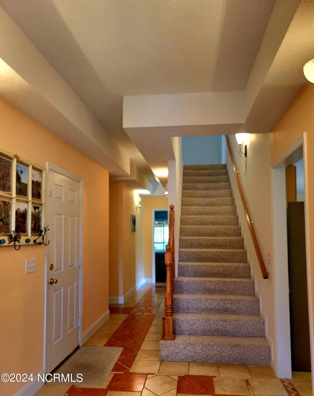 staircase with tile patterned flooring and baseboards