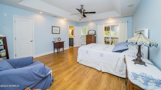 bedroom with recessed lighting, a raised ceiling, visible vents, wood finished floors, and baseboards