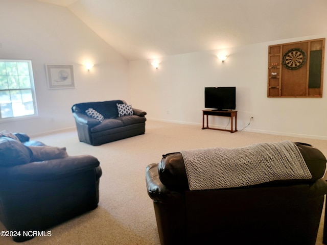 carpeted living area with lofted ceiling and baseboards