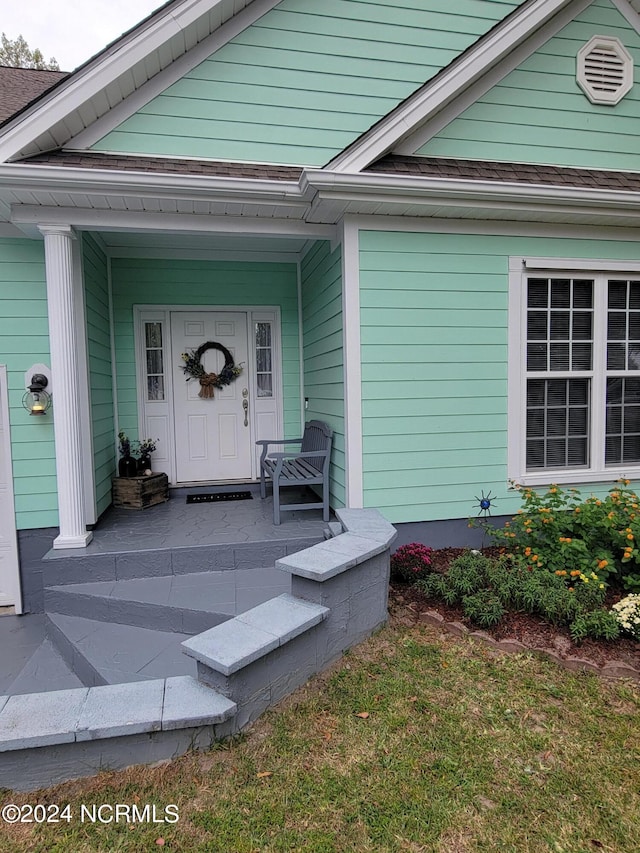 view of exterior entry with covered porch