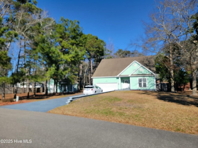 view of front of home with driveway, an attached garage, and a front lawn