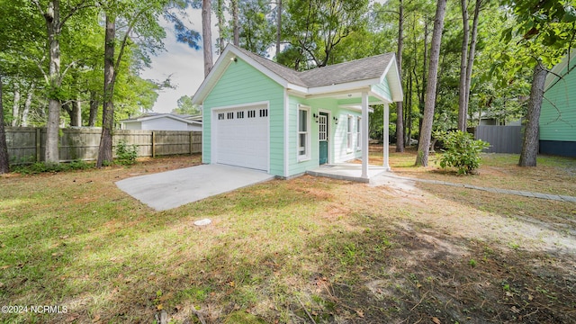 garage featuring driveway and fence