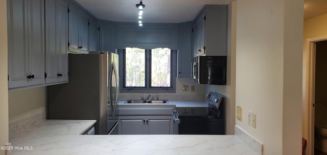 kitchen with stainless steel appliances, a sink, and light countertops