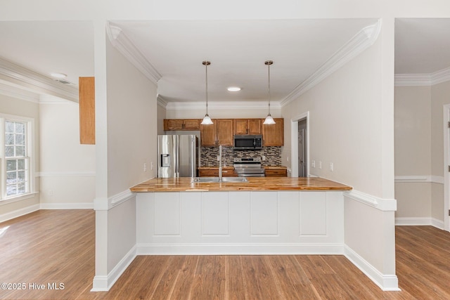 kitchen with stainless steel appliances, light countertops, and a peninsula