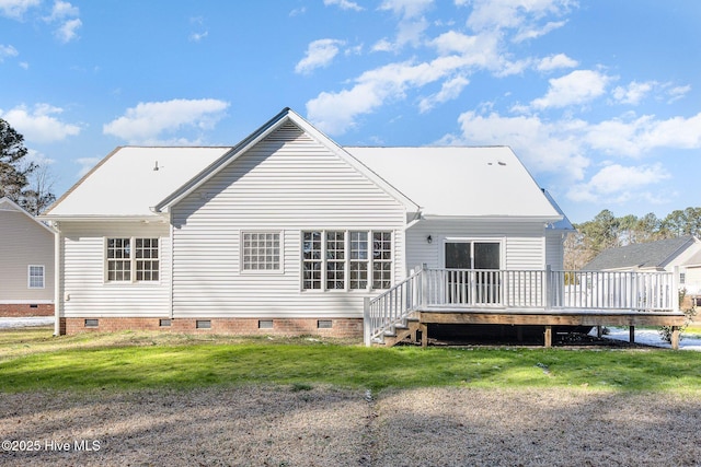 rear view of house featuring crawl space, a deck, and a lawn