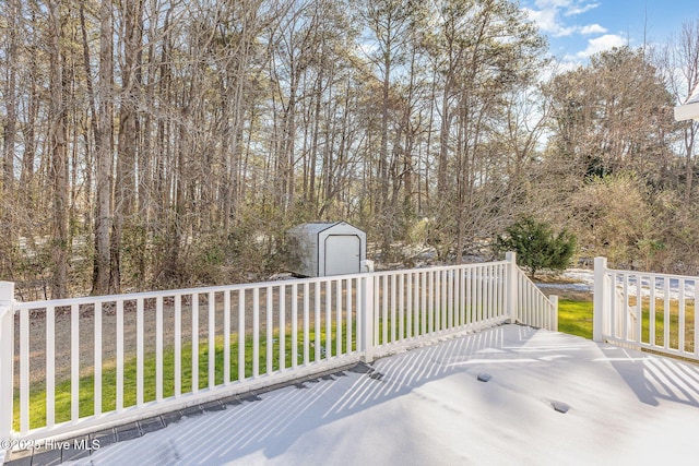 wooden deck with an outbuilding, a yard, a storage unit, and fence