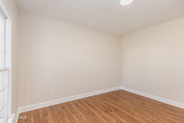 empty room featuring wood finished floors and baseboards