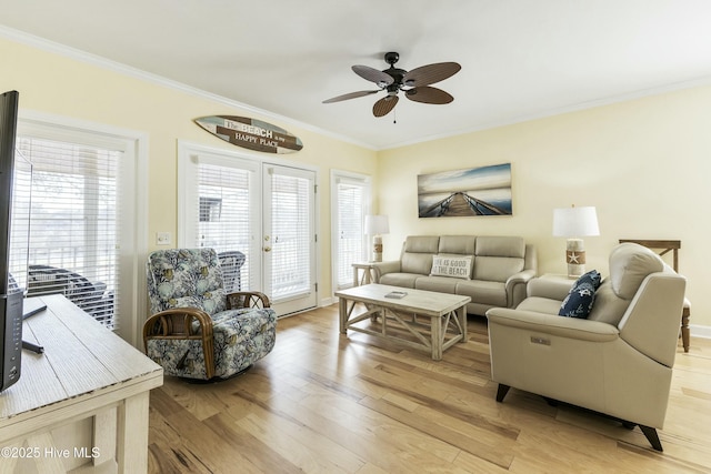 living room featuring ornamental molding, light wood finished floors, and a ceiling fan