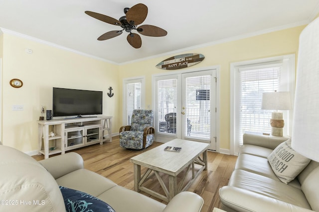 living room with baseboards, ceiling fan, wood finished floors, and crown molding