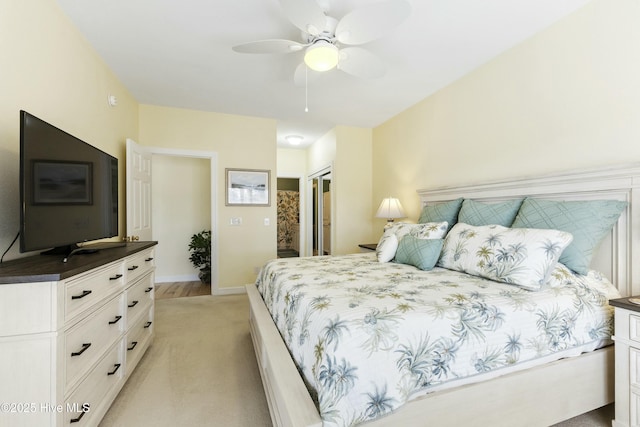 bedroom featuring a ceiling fan, a closet, light colored carpet, and baseboards