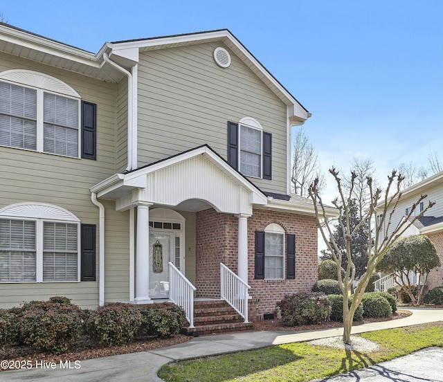 view of front of house with covered porch and brick siding