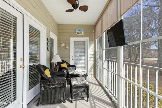 sunroom / solarium featuring a ceiling fan