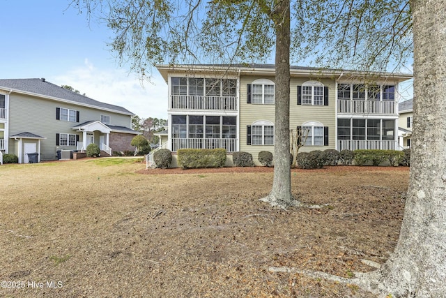 view of front of house featuring a sunroom and a front yard