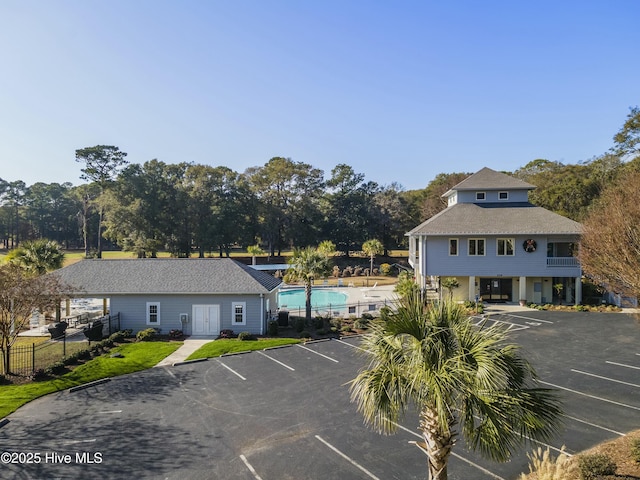 uncovered parking lot with fence and a fenced in pool