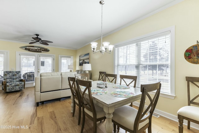 dining area featuring light wood finished floors, plenty of natural light, and crown molding