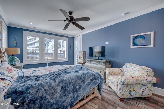 bedroom with baseboards, visible vents, wood finished floors, crown molding, and recessed lighting