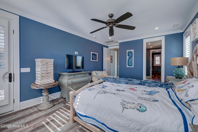 bedroom with visible vents, wood finished floors, attic access, and crown molding