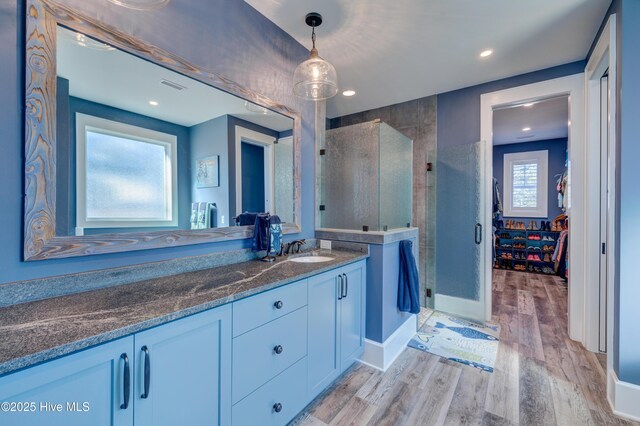 full bathroom featuring vanity, baseboards, wood finished floors, and ensuite bathroom