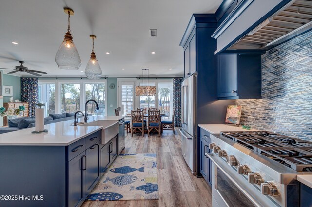 kitchen featuring blue cabinetry, stainless steel appliances, and a sink