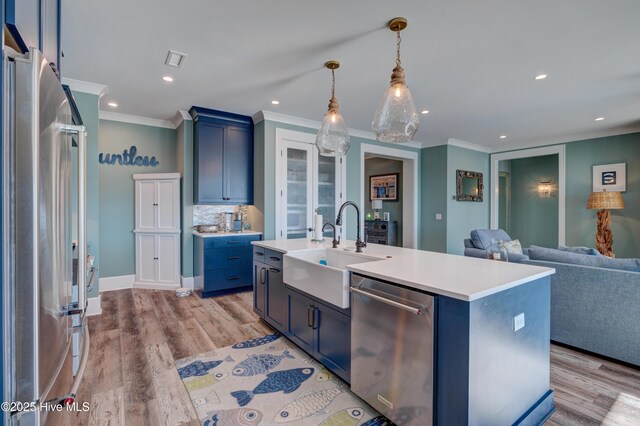 kitchen featuring visible vents, light countertops, ornamental molding, blue cabinetry, and high end appliances