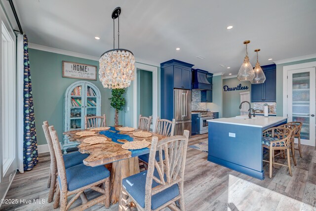 kitchen featuring premium appliances, light countertops, decorative backsplash, a sink, and blue cabinets