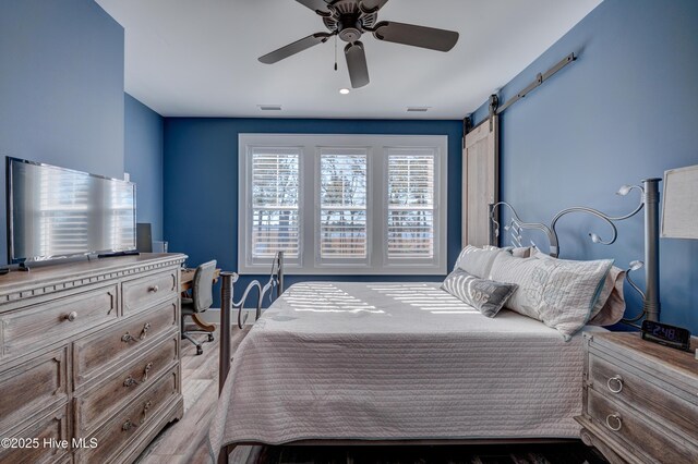 bedroom featuring visible vents, ceiling fan, and light wood finished floors