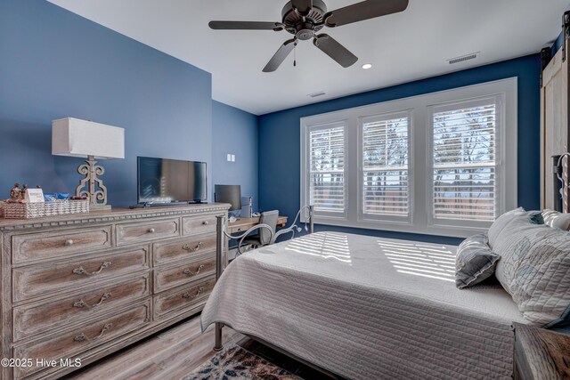 bedroom featuring ceiling fan, baseboards, and wood finished floors