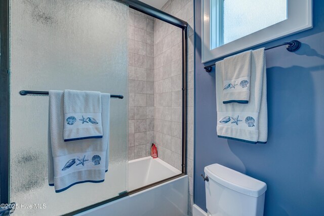 bedroom with light wood-style floors, ensuite bath, baseboards, and ceiling fan