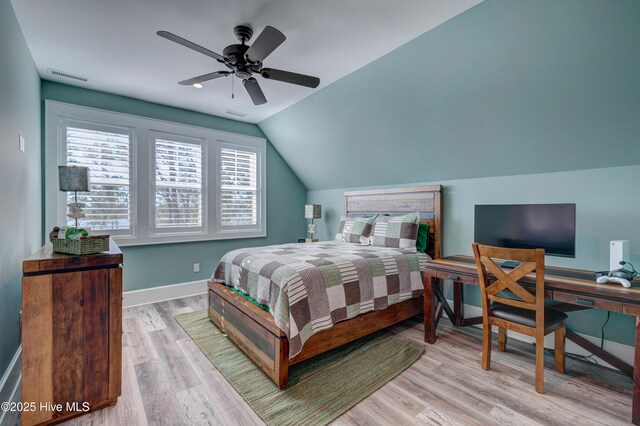 bedroom featuring lofted ceiling, a sink, visible vents, baseboards, and light wood-style floors