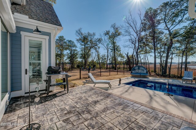 view of pool featuring a water view, a fenced backyard, a fenced in pool, and a patio