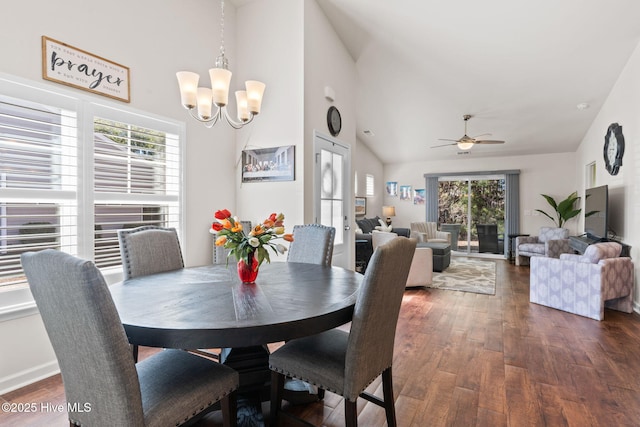 dining area with ceiling fan with notable chandelier, high vaulted ceiling, and wood finished floors