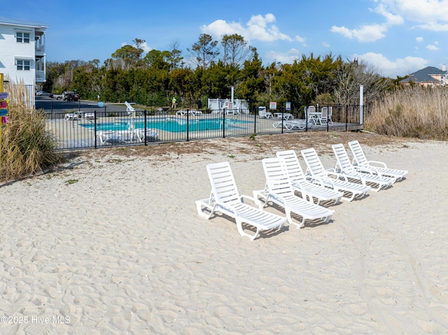 community pool with a patio area and fence